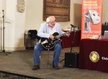 Pieter speelt gitaar tijdens presentatie